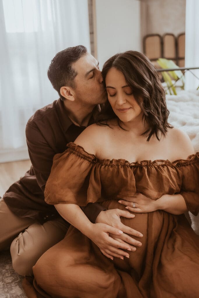 Parents embracing and holding expecting mothers stomach