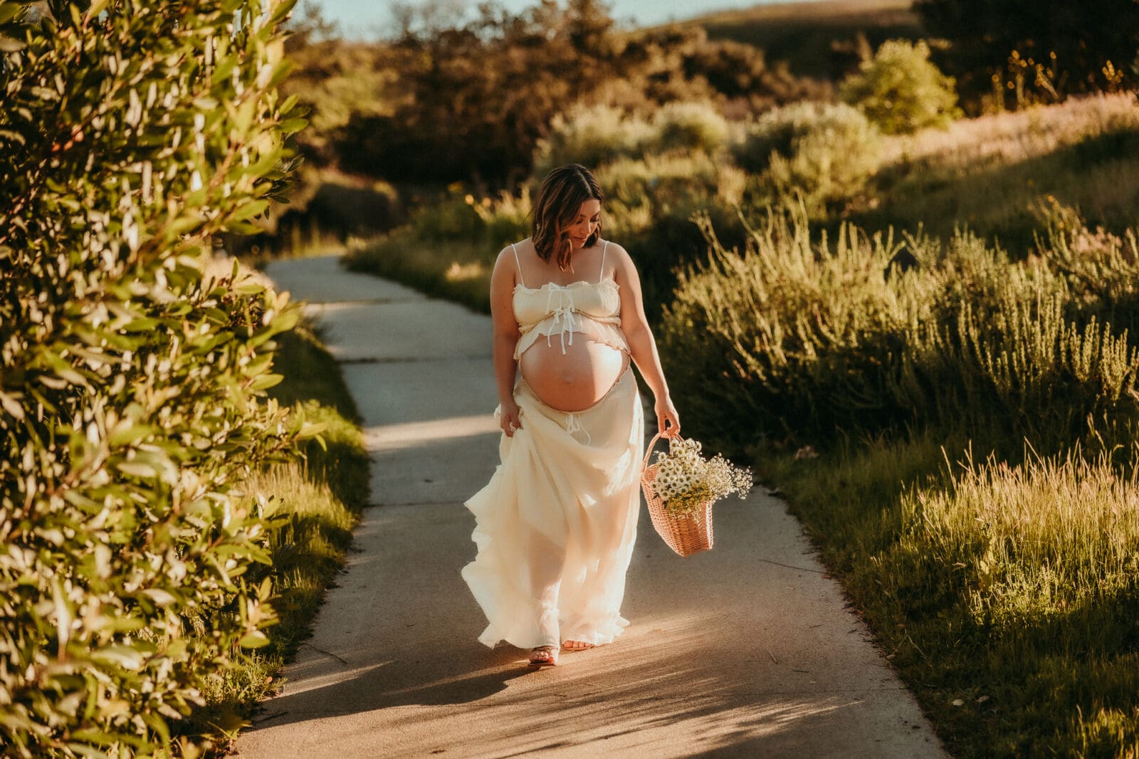 Pregnant woman walking holding a basket of flowers at Chino Hills state park