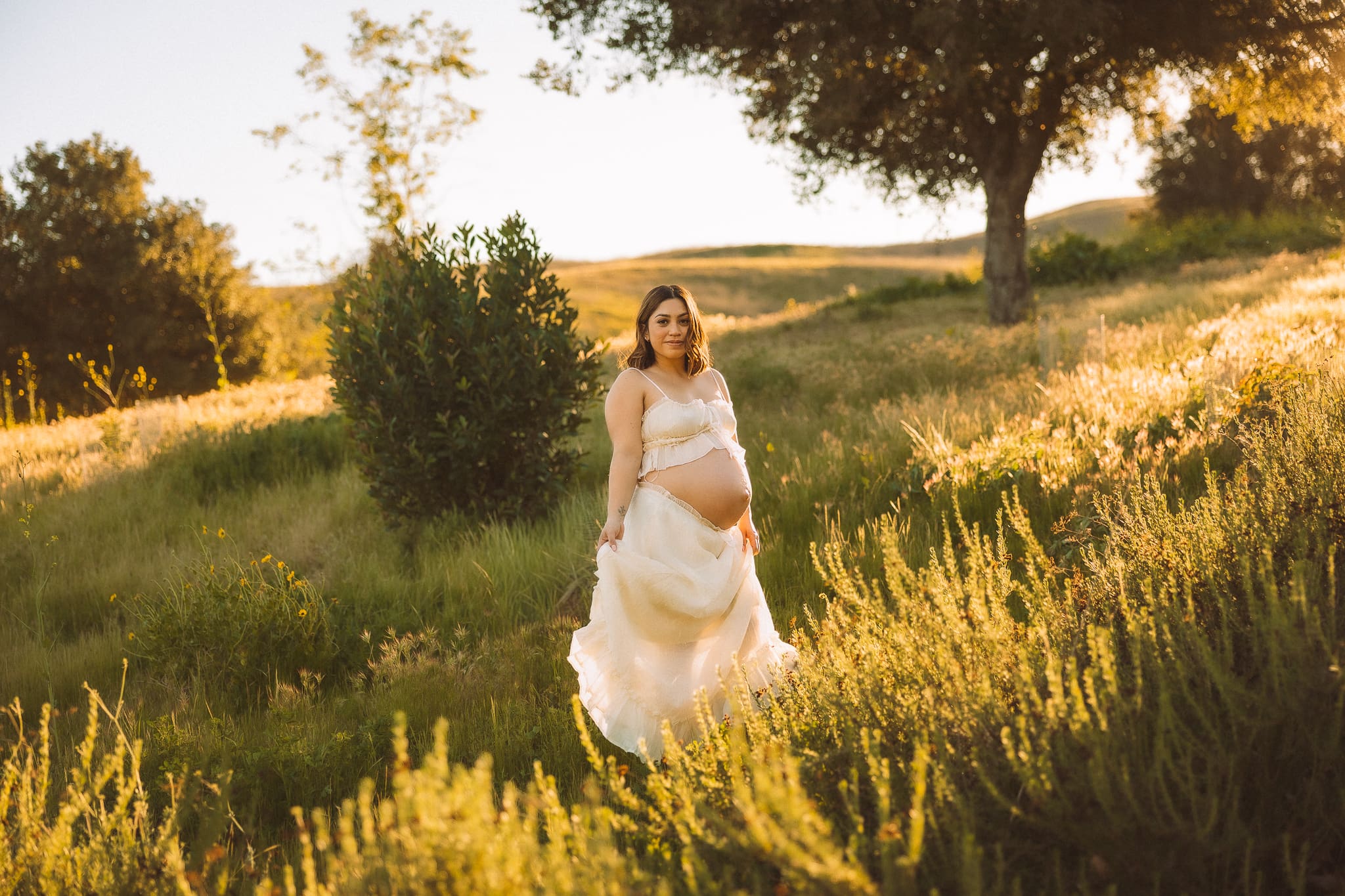 Pregnant mom twirling her dress in an open field at Chino Hills State Park.